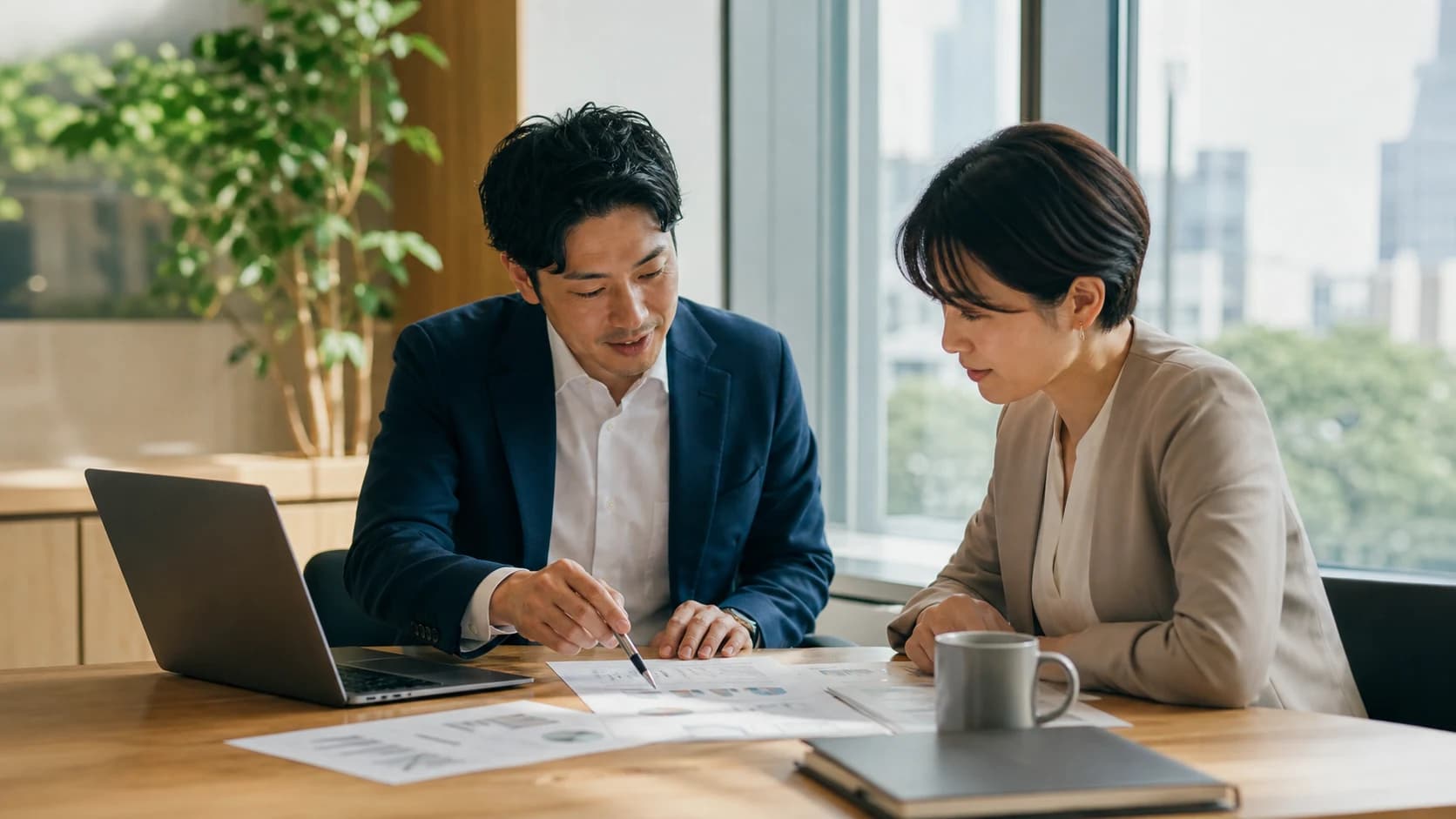 お客様と並んで資料を見ながら議論するシーン
